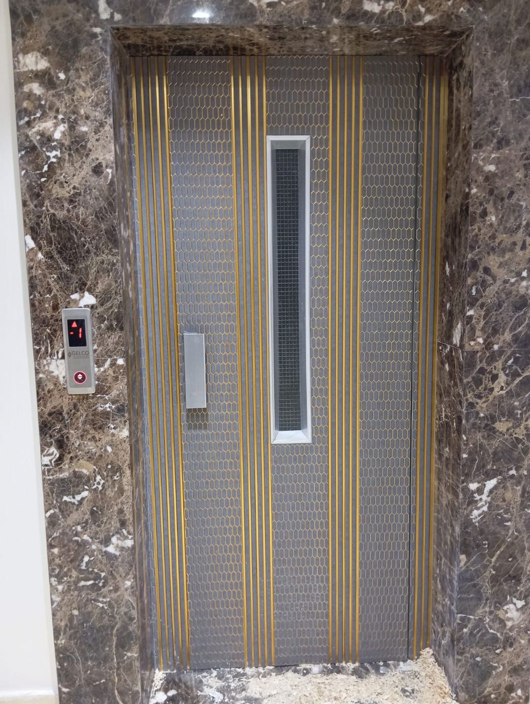 Porte palière dorée sur marbre — réalisation GELCO